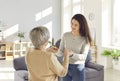 Happy adult daughter holding hands with her senior old mother standing at home Royalty Free Stock Photo