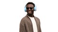 Portrait of happy smiling african man in wireless headphones listening to music looking away isolated on white background Royalty Free Stock Photo