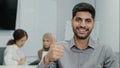 Portrait of happy smiling arab male business leader making thumb up like gesture at camera. Employee satisfied with job Royalty Free Stock Photo