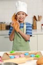 Portrait of Happy smiling Asian boy with apron and chef hat, holding baguette French bread while standing at kitchen, cute child Royalty Free Stock Photo