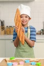 Portrait of Happy smiling Asian boy with apron and chef hat, holding baguette French bread while standing at kitchen, cute child Royalty Free Stock Photo