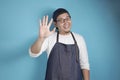 Portrait of happy smiling Asian chef or waiter shows high five or hand waving gesture