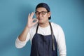 Portrait of happy smiling Asian chef or waiter shows OK delicious hand gesture Royalty Free Stock Photo