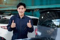 Portrait of happy smiling Asian handsome mechanic man in uniform giving thumbs up to camera, auto mechanic technician repairing Royalty Free Stock Photo