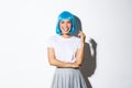 Portrait of happy smiling asian woman in blue shirt wig and shoolgirl costume looking at camera, dressed for halloween