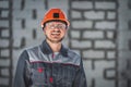 Portrait of a happy smiling bearded Caucasian worker in overalls, safety helmet and safety glasses at a construction Royalty Free Stock Photo