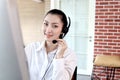 Portrait of happy smiling beautiful Asian woman with headphones work with computer at call center service desk, female agent with Royalty Free Stock Photo