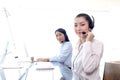 Portrait of happy smiling beautiful Asian woman with headphones work with computer at call center service desk, female agent with Royalty Free Stock Photo