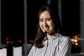 Portrait of happy smiling beautiful Asian woman with headphones work night shift at call center customer care service desk, Royalty Free Stock Photo