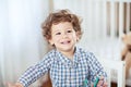 Portrait of happy smiling beautiful little boy in babyroom - checked shirt