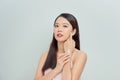 Portrait of happy smiling beautiful young woman touching skin or applying cream, isolated over white background Royalty Free Stock Photo