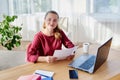 Portrait of happy smiling business woman sitting at wooden desk with laptop and working with documents at home office, copy space Royalty Free Stock Photo