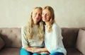 Portrait of happy smiling caucasian middle aged mother hugging her adult daughter together sitting on couch at home Royalty Free Stock Photo