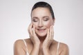 Portrait of happy smiling charming, beautiful woman touching skin or applying cream, with perfect skin after cream, balm, mask,