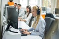 Portrait of happy smiling cheerful support phone operator in headset working on computer in call center. Royalty Free Stock Photo