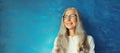 Portrait of happy smiling confident middle-aged woman in eyeglasses looks away. Gray-haired female in casual on blue background Royalty Free Stock Photo