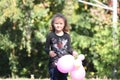 Portrait of happy smiling cute little girl child outdoors with colorful baloons