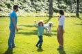 Portrait of a happy smiling family with dog relaxing in park. Royalty Free Stock Photo