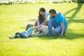 Portrait of a happy smiling family with pet dog relaxing in park. Royalty Free Stock Photo