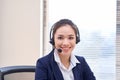 Portrait of happy smiling female customer support phone operator at workplace. Asian Royalty Free Stock Photo