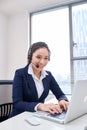 Portrait of happy smiling female customer support phone operator at workplace. Asian Royalty Free Stock Photo