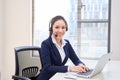 Portrait of happy smiling female customer support phone operator at workplace. Asian Royalty Free Stock Photo