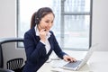 Portrait of happy smiling female customer support phone operator at workplace. Asian Royalty Free Stock Photo