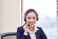 Portrait of happy smiling female customer support phone operator at workplace. Asian Royalty Free Stock Photo