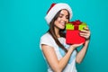 Portrait of a happy smiling girl in dress holding present box over green background Royalty Free Stock Photo