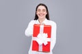 Portrait of a happy smiling girl holding present box and isolated over gray background. Royalty Free Stock Photo