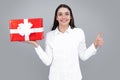 Portrait of a happy smiling girl holding present box and isolated over gray background. Royalty Free Stock Photo