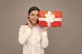 Portrait of a happy smiling girl holding present box and  over gray background. Royalty Free Stock Photo