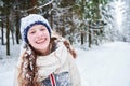 Portrait of happy smiling girl in winter snowy forest