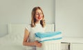 Portrait of happy smiling housewife woman holding wicker laundry basket with clean folded towels on the bed Royalty Free Stock Photo