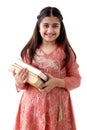 Portrait of happy smiling Indian school girl child with long hair and beautiful eyes wearing traditional dress costume, holding Royalty Free Stock Photo