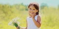 Portrait happy smiling little girl child with bouquet of wildflowers in sunny summer day Royalty Free Stock Photo