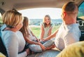 Portrait of happy smiling little girl gazing at camera. Happy young couple with two daughters inside the car trunk during auto Royalty Free Stock Photo