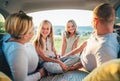 Portrait of happy smiling little sisters. Happy young couple with two daughters inside the car trunk during auto trop. They are Royalty Free Stock Photo