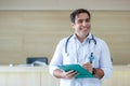 portrait happy smiling male doctor white coat holding folder document. Royalty Free Stock Photo