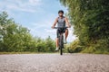 Portrait of a happy smiling man dressed in cycling clothes, helmet and sunglasses riding a bicycle on the asphalt out-of-town Royalty Free Stock Photo