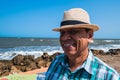 Portrait of a happy, smiling man with a hat at the bottom of a beach