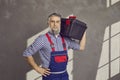 Portrait of a happy smiling mature bearded repairman holding a tool box isolated on gray background Royalty Free Stock Photo