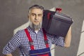 Portrait of a happy smiling mature bearded repairman holding a tool box isolated on gray background Royalty Free Stock Photo