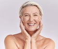 Portrait of a happy smiling mature caucasian woman looking positive and cheerful while posing topless in a studio Royalty Free Stock Photo