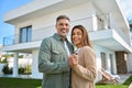 Portrait of happy mature family couple property owners standing outside house. Royalty Free Stock Photo