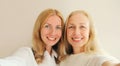 Portrait of happy smiling middle aged mother and adult daughter taking selfie with phone together Royalty Free Stock Photo