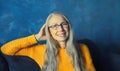 Portrait of happy smiling middle-aged woman in eyeglasses looks at the camera. Senior blonde woman in casual on blue background Royalty Free Stock Photo