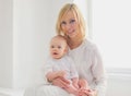 Portrait of happy smiling mother and cute little baby in white room at home Royalty Free Stock Photo