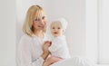 Portrait of happy smiling mother and cute little baby in white room at home Royalty Free Stock Photo