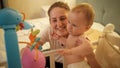 Portrait of happy smiling mother hugging her adorable baby boy in diapers standing in bed at night Royalty Free Stock Photo